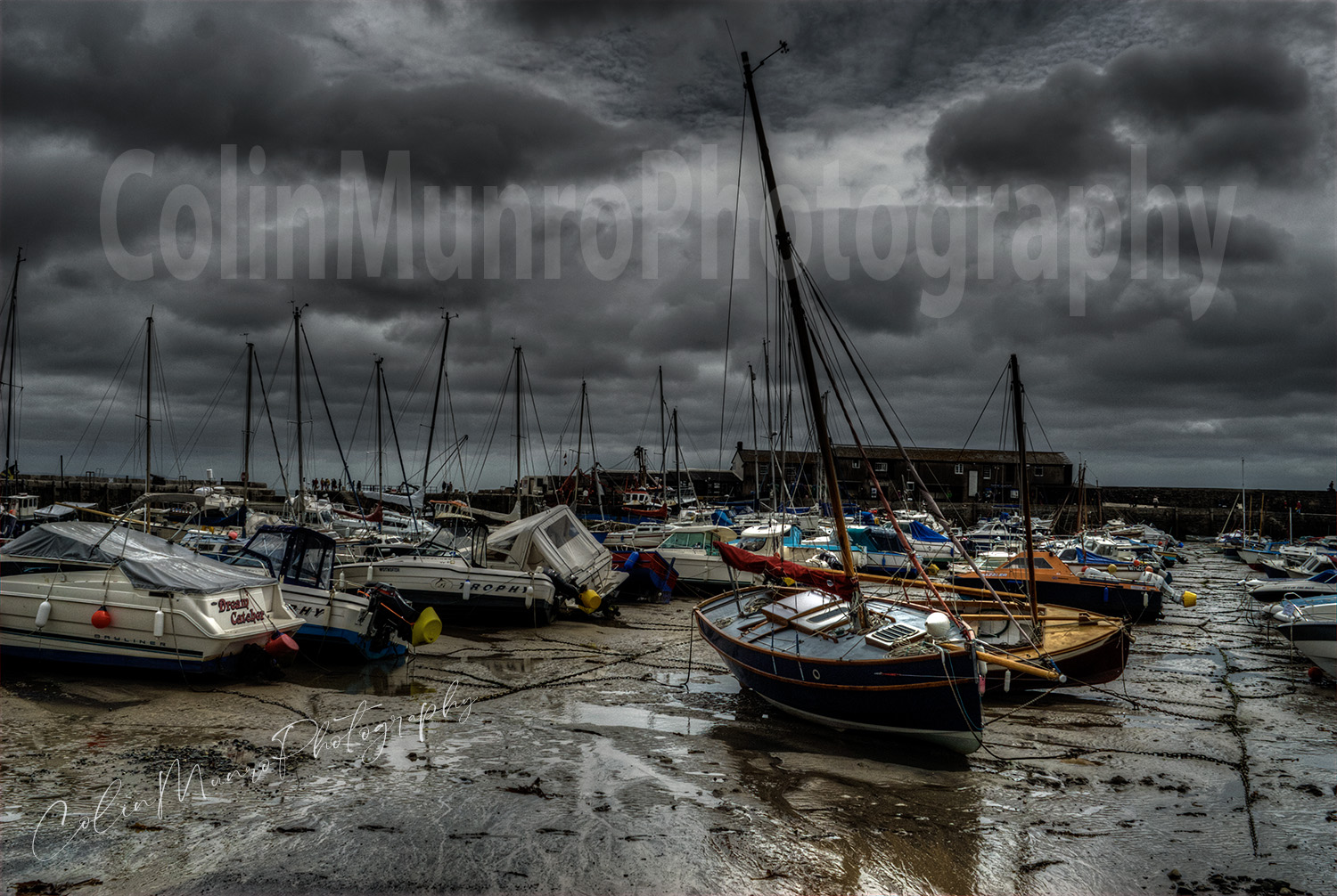 The Cobb, Lyme Regis, Fine Art Print for sale. The Cobb at low water. Lyme Regis harbour, known as The Cobb. Moored boats sit on mud at low water. Lyme Regis is a drying harbour; the mudflats are exposed as the harbour dries at low water. Lyme Regis, Dorset, England. ©Colin Munro Photography
